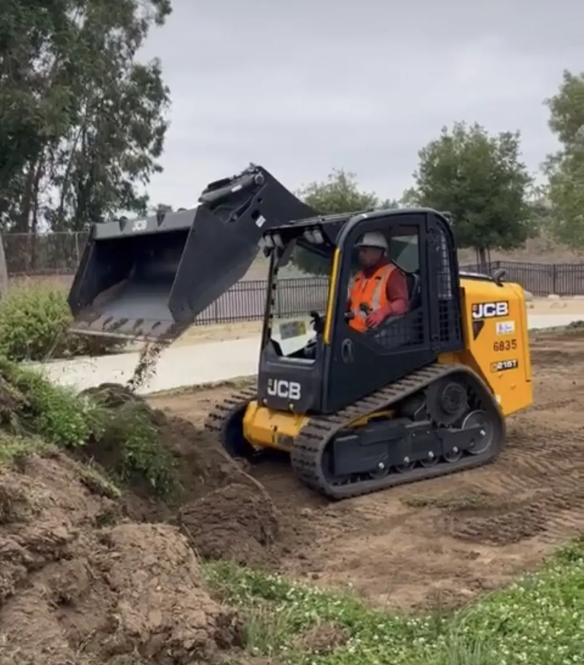 Tracked skid steer moving dirt